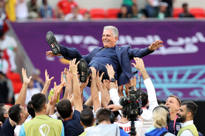 Los jugadores de Irán celebran con el entrenador en jefe Carlos Queiroz después de ganar el partido de fútbol del grupo B de la Copa Mundial de la FIFA 2022 entre Gales e Irán