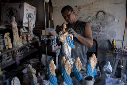 Managua. Un hombre exhibe las esculturas de la Virgen en las que trabaja en estos días.