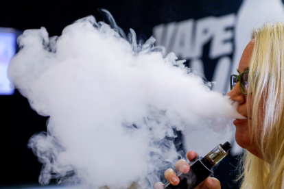 Fotografía de archivo de una mujer consumiendo un cigarrillo electrónico en un comercio especializado en estos productos.