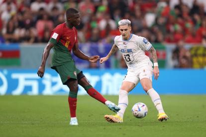 Nuno Mendes (i), defensor portugués, disputando una pelota con el uruguayo Guillermo Varela.