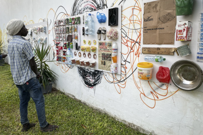 Decenas de botes arrojados a la basura envasados al vacío se exponen en el Instituto Cervantes de Dakar junto a las fotografías de sus consumidores, un proyecto del colectivo español Basurama ./