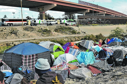 MEX917. CIUDAD JUÁREZ (MÉXICO), 24/11/2022.- Migrantes reciben hoy alimentos en un campamento junto al Río Bravo con motivo del día de Acción de Gracias, en Ciudad Juárez, estado de Chihuahua (México). Migrantes del norte de México apoyaron a otro grupo de indocumentados en situación vulnerable proveyéndolos de alimento con motivo del Día de Acción de Gracias. Más de 3.000 platillos fueron elaborados con un esfuerzo de más de dos días seguidos de preparación por parte de voluntarios que buscan llevar un mensaje de alegría y fe en esta festividad. EFE/Luis Torres