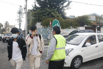Organización. Los padres deben meterse en el tráfico para mostrar el letrero de ‘pare’ y dar tiempo a los chicos para que crucen la calle.