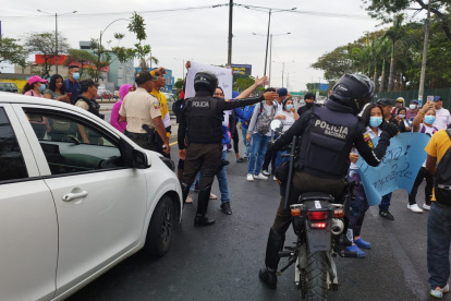 Trabajadores de la empresa Turbo Limpieza, que brinda sus servicios al hospital Teodoro Maldonado Carbo, protestan afuera de la entidad, en la avenida 25 de Julio.