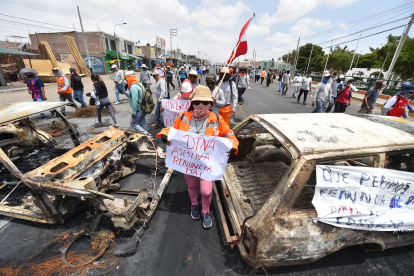 Simpatizantes de Pedro Castillo caminan entre dos vehículos incinerados mientras se manifiestan para pedir la salida de la presidenta Dina Boluarte y el cierre del Congreso hoy, en el distrito de la Joya, en Arequipa (Perú). Dieciocho personas han muerto desde que este domingo comenzaron las manifestaciones y protestas que exigen el adelanto de elecciones, la renuncia de la presidenta Dina Boluarte, el cierre del Congreso y la convocatoria a una asamblea constituyente. EFE/ José Sotomayor Jiménez