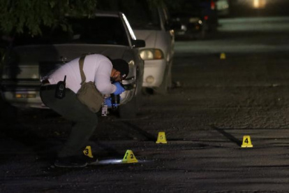 Referencia. En México, peritos recaban indicios en el lugar donde asesinaron a un periodista.