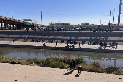 Migrantes esperan para cruzar el río hoy, en la valla fronteriza de El Paso, Texas, frente a Ciudad Juárez, México. EFE/Octavio Guzmán