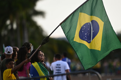 AME2471. BRASILIA (BRASIL), 22/12/2022.- Simpatizantes del presidente de Brasil, Jair Bolsonaro, se manifiestan a su favor frente al Palacio de la Alvorada, en Brasilia (Brasil). El presidente de Brasil, Jair Bolsonaro, que dejará el poder el próximo 1 de enero, sancionó un proyecto de ley que establece directrices para el mercado de criptomonedas en el país, según fue publicado este jueves en el Diario Oficial. EFE/ Andre Borges