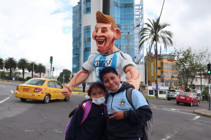 Dos niños posan junto a un monigote de Lionel Messi, el 28 de diciembre de 2022, en Quito (Ecuador).