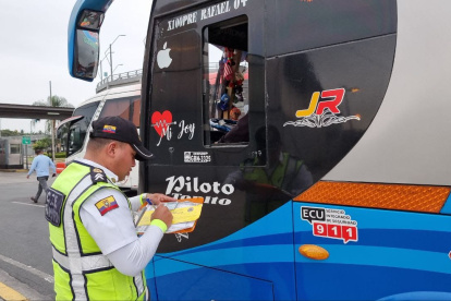 Controles. Un agente de la CTE revisa la documentación de un bus.