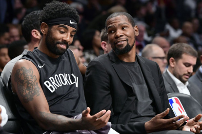 Descanso. Kyrie Irving (i) y Kevin Durant, de los Nets, durante un partido de la NBA donde no fueron utilizados.