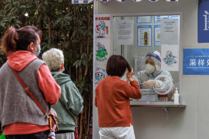 Shanghái. Ciudadanos hacen fila por un test PCR de coronavirus.
