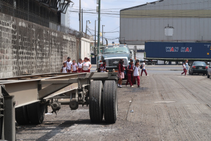 Los alumnos del José María Egas caminan entre los camiones parqueados en los alrededores del colegio.