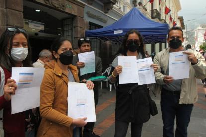 Molestia. Mientras hace fila en el exterior de un banco, un ciudadano indica cuánto pagó el año pasado