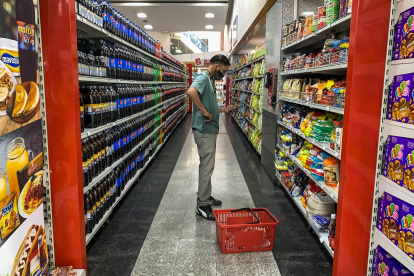 Un hombre revisa su celular mientras compra víveres en un supermercado, este 7 de junio de 2022, en Caracas (Venezuela). EFE/ Miguel Gutiérrez
