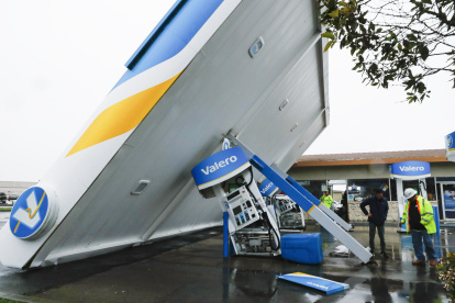 Un trabajador de una estación y uno de servicios públicos revisan los daños en el techo de una estación de servicio Valero en South San Francisco, California, EE. UU. EFE/EPA/JOHN G. MABANGLO