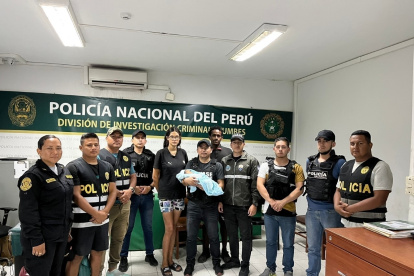 Los padres y el bebé con el grupo de agentes que participaron en la búsqueda.