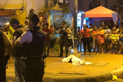 Babahoyo. El cuerpo de la lmujer le dispararon por siete ocasiones mientras salía del reasentamiento Brisa del Río, aparece cubierto con una sábana blanca.
