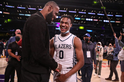 LeBron James (i), junto a su hijo Bronny James, tras un partido.