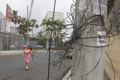 En la calle 10 y B de la ciudadela Adace hay cables enredados en postes y otros que están colgados.