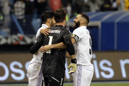 Los jugadores del Real Madrid Marco Asensio (i) y Karim Benzemá (d) felicitan a Thibaut Courtois tras detener el último penalti ante el Valencia.