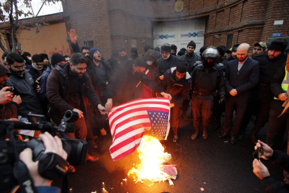 Personas queman una bandera de Estados Unidos durante una protesta frente a la embajada de Francia en Teherán /EFE