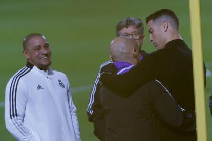 El futbolista portugués Cristiano Ronaldo (d) y el exfutbolista brasileño Roberto Carlos (i) asisten al entrenamiento del Real Madrid.