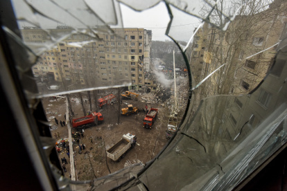 Dnipro (Ukraine), 15/01/2023.- A view taken through the broken glass of a window overlooking the site of a damaged residential building as rescue works continue, in Dnipro, southeastern Ukraine, 15 January 2023, amid Russia"s invasion. At least 25 people died, including one child, 73 other were injured, including 13 children, and 43 reports of missing persons were received, after a rocket hit a nine-story building in Dnipro on 14 January, the State Emergency Service (SES) of Ukraine said in a statement. Russian troops entered Ukraine on 24 February 2022 starting a conflict that has provoked destruction and a humanitarian crisis. (Atentado, Rusia, Ucrania) EFE/EPA/OLEG PERTASYUK