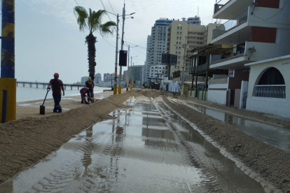 Personal del Municipio de Santa Elena trabaja con maquinaria para poder retirar la arena de la playa que se encuentra en la vía