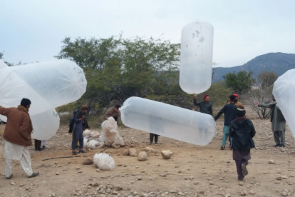 Los residentes locales llenan bolsas de plástico con gas natural para cocinar en casa, en el distrito de Karak, en el noroeste de Pakistán, que presume de ricas reservas de gas natural y petróleo. EFE/EPA/BASIT GILANI