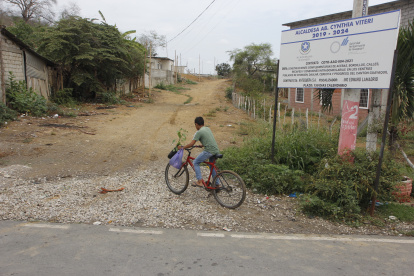 Obras. Las localidades al pie de un letrero que anuncia obras en la parroquia siguen en pura tierra.