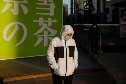 Una mujer con mascarilla camina por la calle en Pekín el 16 de enero de 2023. EFE/EPA/WU HAO