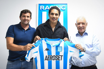 Paolo Guerrero (c) se muestra feliz sosteniendo la camiseta de Racing.