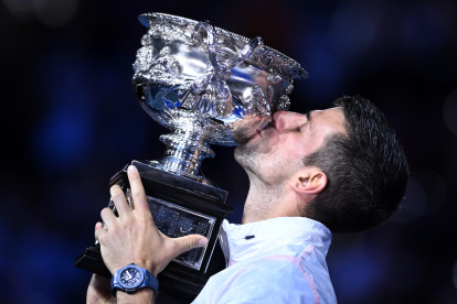 Novak Djokovic, campeón del Abierto de Australia, besa el trofeo ganado este domingo 29 de enero.