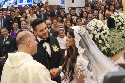 Durante la ceremonia, los esposos con el padre Diego.