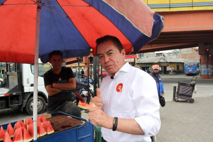 Chillogallo. Previo al inicio del recorrido, el candidato degusta de una porción de sandía, en un puesto ambulante del sector