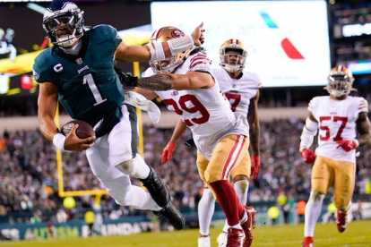 Julen Hurts, de Eagles (i) y Patrick Mahomes, de Chiefs (detrás) harán historia en el Super Bowl 2023.