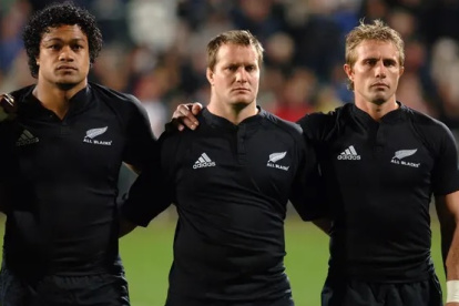 Campbell Johnstone (c) con dos de los integrantes del equipo cuando vestía la camiseta.