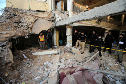 Oficiales de seguridad paquistaníes inspeccionan la escena un día después de la explosión de una bomba suicida en una mezquita en líneas policiales, en Peshawar, provincia de KPK, Pakistán