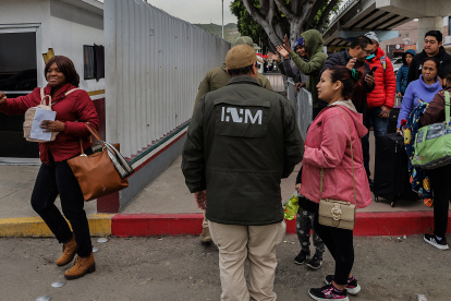 Grupos de personas migrantes hacen fila para cruzar a Estados Unidos y continuar con su proceso de asilo a través de la garita internacional del Chaparral ayer, en Tijuana, Baja California (México). EFE/ Joebeth Terríquez