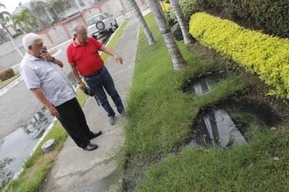 1. Las calles. Las aguas de los pozos sépticos se rebosan hasta las vías principales de las urbanizaciones. Los residentes evitan cruzar por las aceras por el agua maloliente.