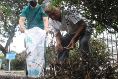 Xavier y Carlos recogen la basura del parque porque nadie más lo hace.
