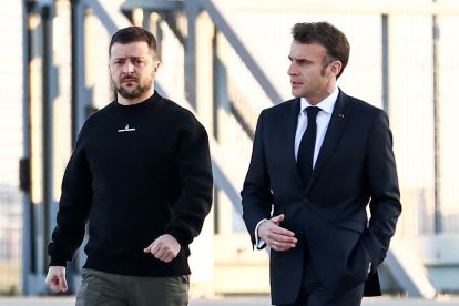 El presidente francés, Emmanuel Macron (d), camina junto al presidente de Ucrania, Volodimir Zelenski (i), antes de dirigirse a Bruselas.