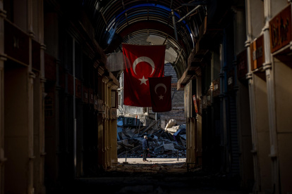 Un hombre se encuentra en medio de una calle junto a un edificio derrumbado tras un fuerte terremoto, en la ciudad de Hatay, Turquía, el 14 de febrero de 2023.