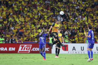 El volante de Barcelona Bruno Piñatares (d), cabecea una pelota junto al delantero de Emelec Alejandro Cabeza (i) en el Clásico del Astillero que terminó igualado 1-1 en el estadio Monumental en mayo de 2022.