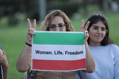 Imagen de archivo de una protesta donde una mujer enseña una bandera iraní con el eslogan: "Mujer. Vida. Libertad".