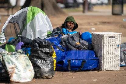 Una mujer sin hogar empaca sus pertenencias antes de que los miembros de un equipo de limpieza del Servicio de Parques Nacionales desalojen un campamento para personas sin hogar el 15 de febrero de 2023, en McPherson Square en Washington (EEUU).
