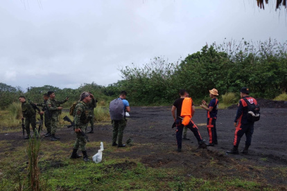 Una foto proporcionada por la Oficina de Protección contra Incendios (BFP) muestra a los bomberos en su camino a la búsqueda de un avión que se estrelló en las cercanías del volcán Mayon.