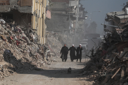 La gente pasa frente a los edificios derrumbados tras los fuertes terremotos en Hatay, Turquía, el 23 de febrero de 2023.