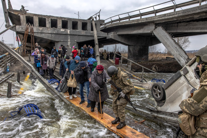 Personas cruzan un puente destruido mientras huyen de la ciudad de primera línea de Irpin, región de Kiev (Kiev), Ucrania, 07 de marzo de 2022.